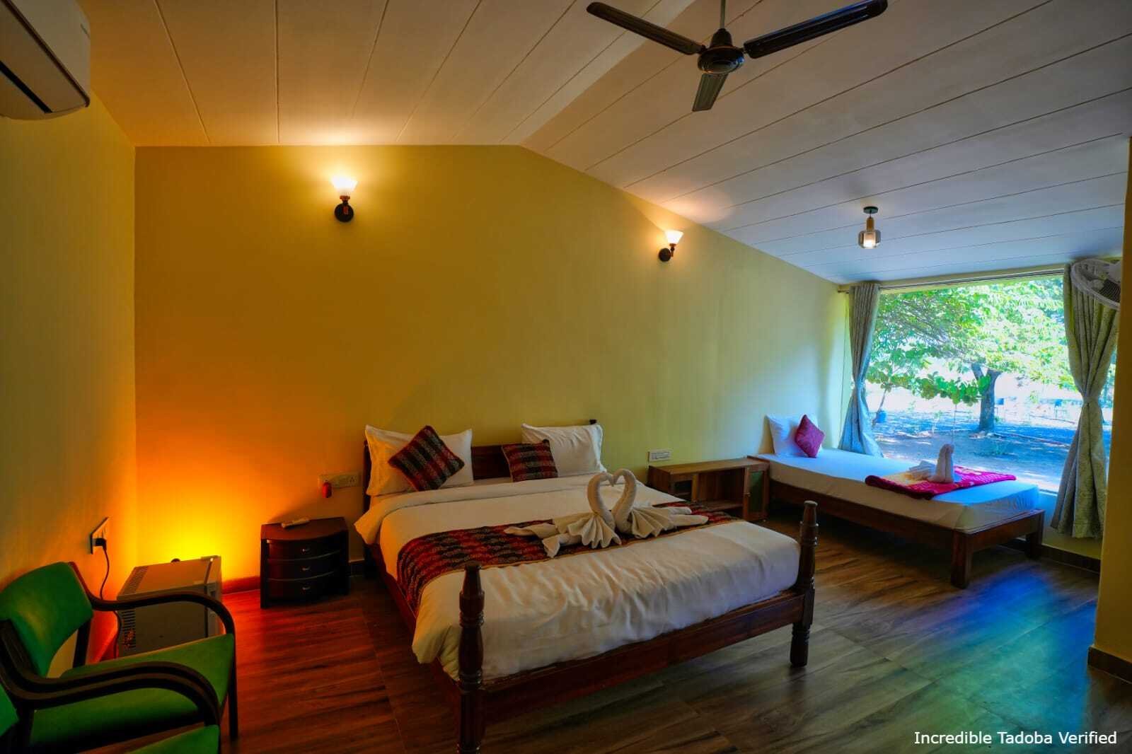 A double bed in a lodge room with a large window onto the trees
