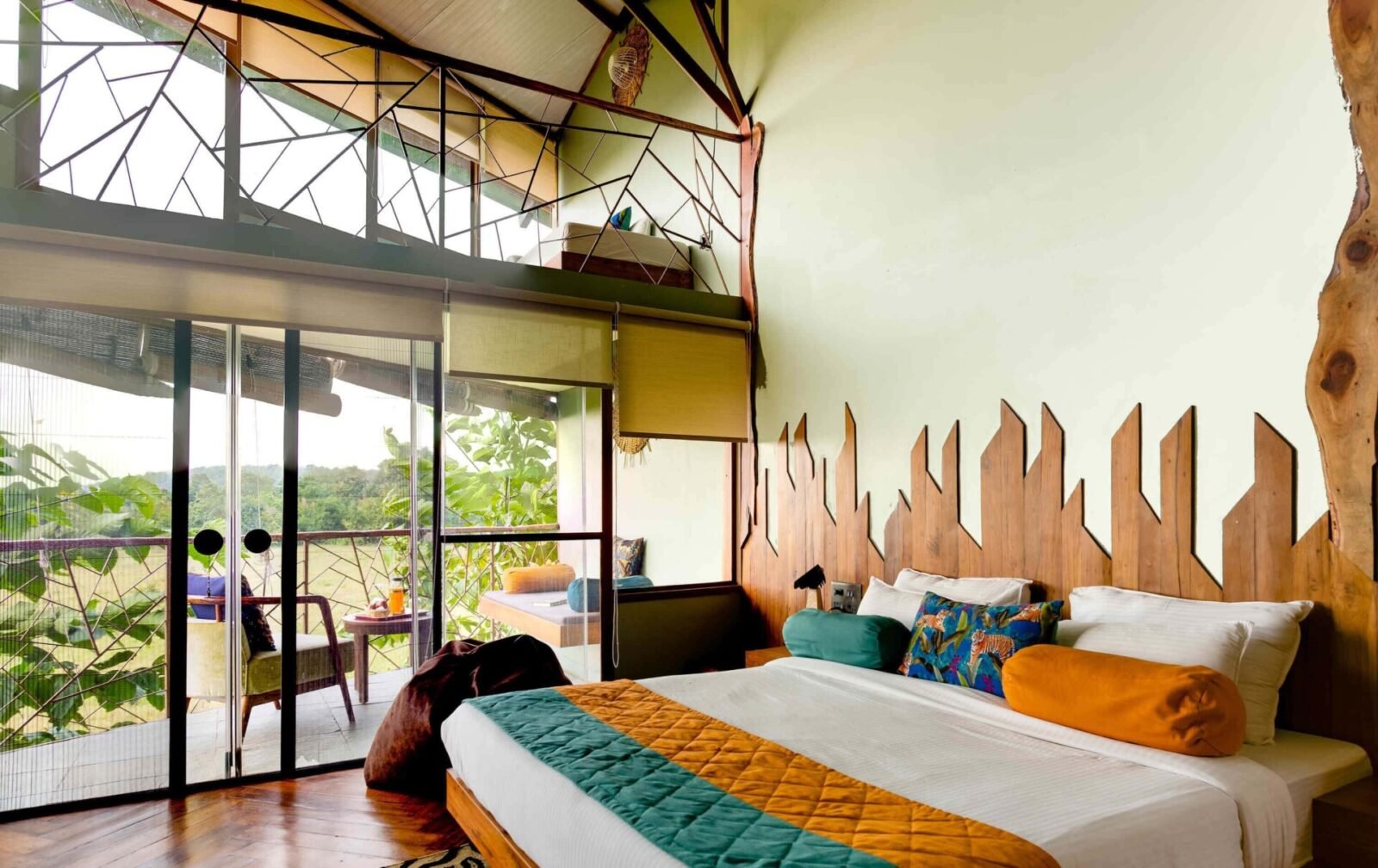 A bed and glass doors opening to a balcony in a forest lodge room