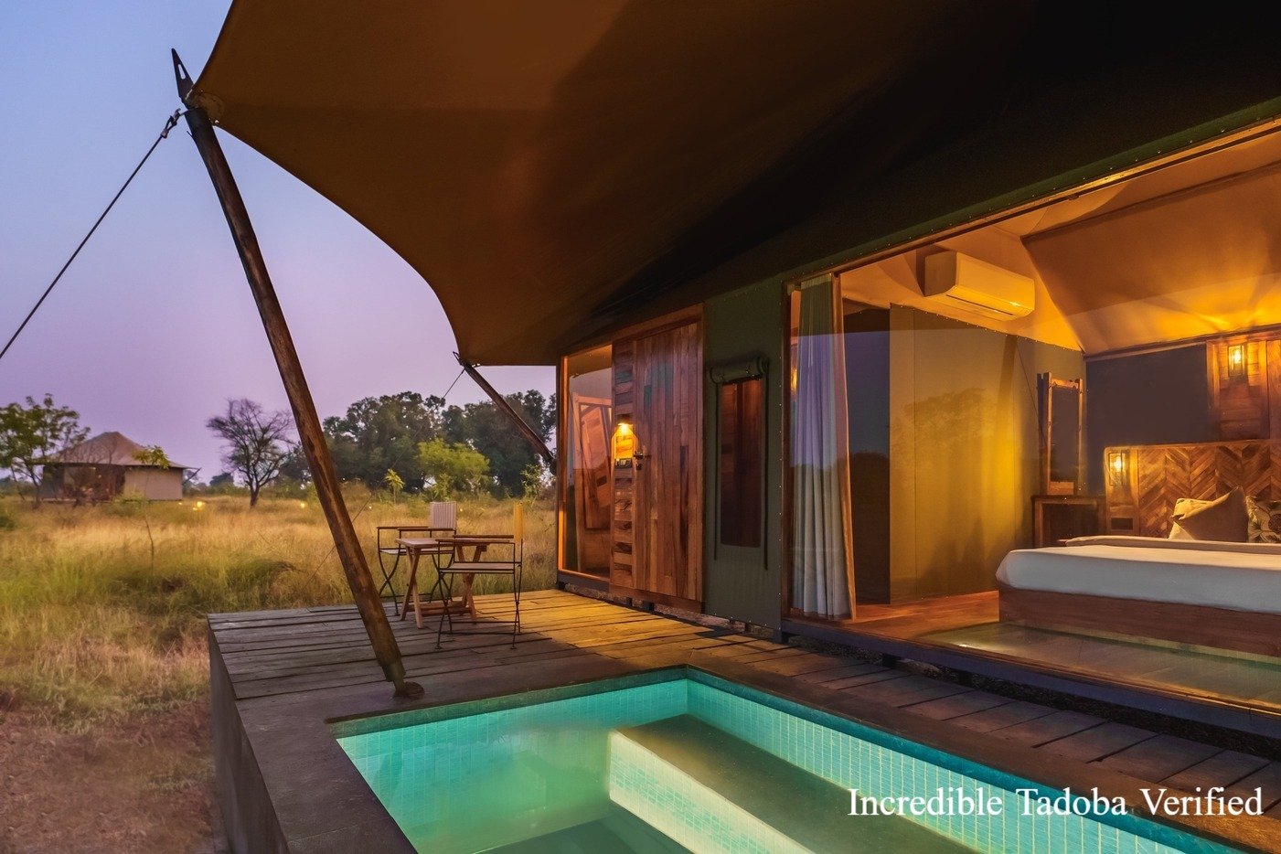 A safari-style tent with a small plunge pool at dusk